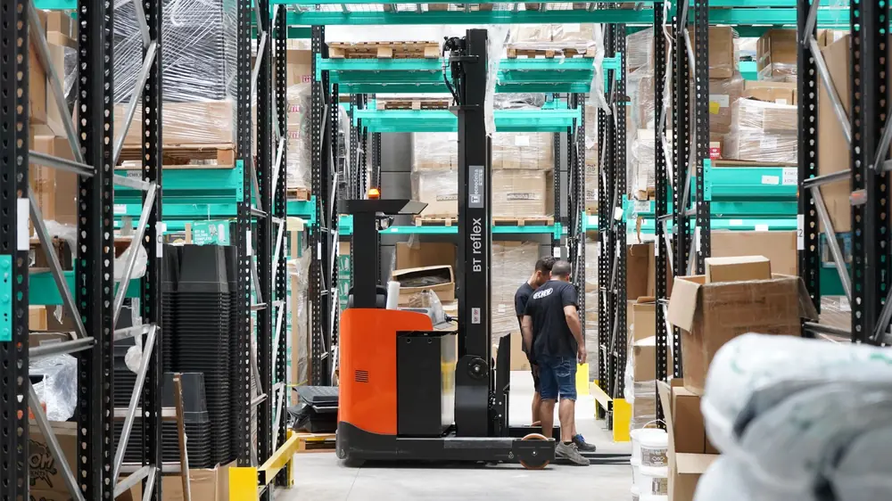Warehouse aisle with shelving and a forklift